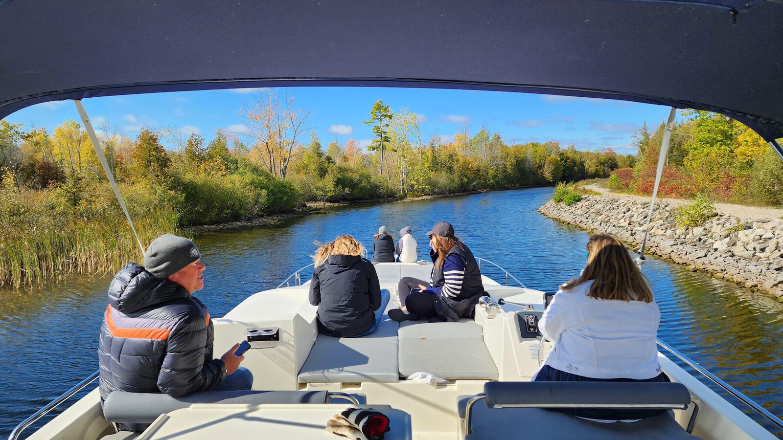 Boaters passing through a Rideau Canal cut in the fall