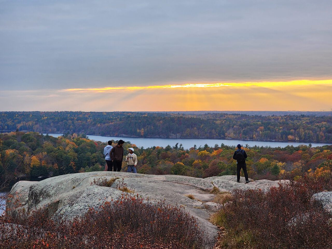 People at a lookout above the lakes and autumn woods